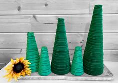 three green plastic cones with a sunflower in the middle