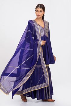 Deep royal blue kurta with gota patti trims and scallop border on the yoke. Comes with gharara and organza dupatta.
Component: 3
Pattern: Embroidery
Type Of Work: Gota Patti
Neckline: V neck
Sleeve Type: Full
Fabric: Silk Chanderi and Organza
Color: Blue
Other Details: 
Dupatta with gota patti border
Occasion: Wedding - Aza Fashions V Neck Kurta, Organza Embroidery, Scallop Border, Blue Kurta, Deep Royal Blue, Pattern Embroidery, Organza Dupatta, Fabric Silk, Blue Silk