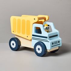 a toy dump truck with a stuffed animal in the back