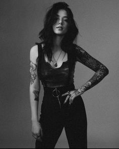 a black and white photo of a woman with tattoos