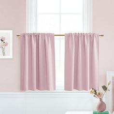 a pink room with curtains and flowers on the window sill