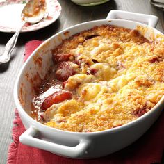 a casserole dish on a table with plates and utensils