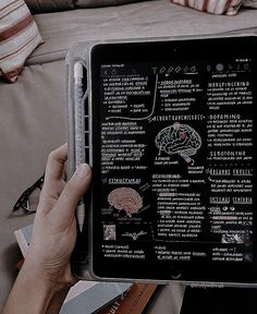 a person is holding an electronic device with many words on it