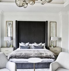 a bedroom with a bed, two chairs and a chandelier