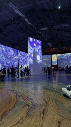 people are sitting on the floor in front of large screens with images of starrdusts