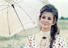 a woman with long hair holding an umbrella