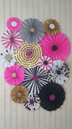 paper flowers are arranged in a circle on the wall with white and black stripes around them