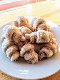 a white plate topped with sugar covered donuts