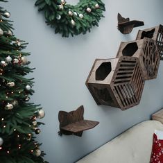 some birds are hanging on the wall next to a christmas tree and other decorations in front of a blue wall