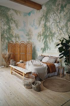 a bed room with a neatly made bed next to a plant and potted plants