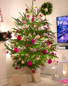 a christmas tree with ornaments and presents in front of a television