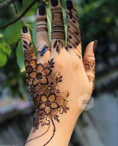 a woman's hand with henna tattoos on it