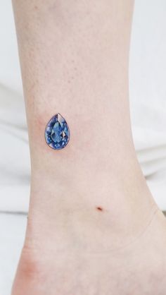 a woman's foot with a small blue diamond on the bottom of her ankle