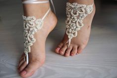 a barefoot bride's foot with white lace and pearls on it, along with her wedding garter