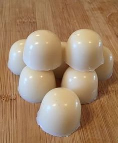 six white eggs sitting on top of a wooden table