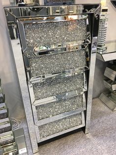 a mirrored display case with lots of silver glitters on the front and bottom shelves