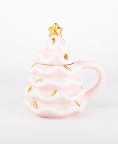 a ceramic cup with a gold star on top and frosted icing in the shape of a christmas tree