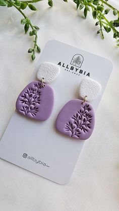 purple and white earrings with flowers on them