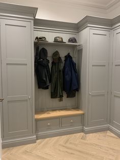 an open closet with several coats hanging on the wall and two coat racks in front of it