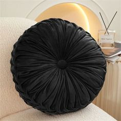 a black round pillow sitting on top of a white couch