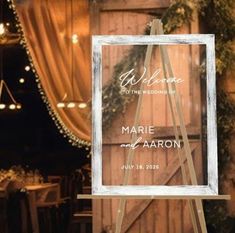 a welcome sign is displayed in front of a wooden wall and decorated with greenery