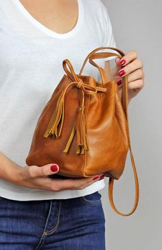 Mini Leather Bucket bag - camel drawstring bag. Unlined The 35.5 inch (90 cm) strap has no adjustment. Beige Leather Bucket Bag For Gift, Beige Leather Bucket Bag As Gift, Camel Bucket Bag For Everyday Use, Camel Bucket Bag For Travel, Camel Everyday Bucket Shoulder Bag, Rectangular Camel Bucket Bag, Brown Bucket Pouch For Everyday Use, Casual Soft Leather Bag As Gift, Casual Brown Satchel As Gift