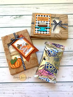 three boxes that have candy in them on top of a wooden table with white boards