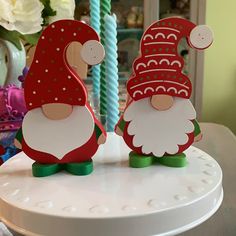 two wooden gnomes sitting on top of a table