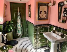 a bathroom with green and pink walls, black and white floor tiles and a sink