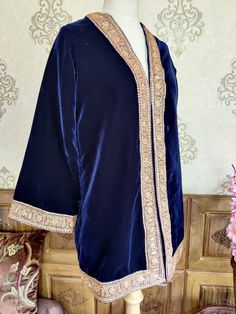 Velvet Kimono, Blue Kashmiri Robe With Gold Tilla Embroidery, Luxury Kimono Robe A luxurious Kashmiri Velvet Robe with Tilla Embroidery, The Fabric Used in This robe Is velvet 9900, One of the finest in the Market and the Golden embroidery is Done By the Lustrous Metallic Thread Known as Tilla,  The robe is of One size as It has a kimono Look and The arms are of bell shape though if you want we can also customise it into jacket fit  DETAILS:  Embroidery: Tilla Work  Length: 32(125 cm) Lining: Fu Elegant Blue Kaftan With Dupatta, Traditional Blue Kaftan With Dupatta, Bohemian Wedding Kaftan With Cutdana, Embroidered Indigo Traditional Wear For Wedding, Bohemian Kaftan With Embroidered Border, Bohemian Kaftan With Embroidered Border And Traditional Drape, Elegant Festive Kaftan With Embroidered Border, Elegant Embroidered Kimono For Eid, Elegant Blue Kurta For Traditional Ceremonies