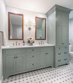 a bathroom with double sinks and two mirrors