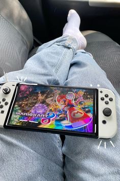 a nintendo wii game controller sitting on someone's lap