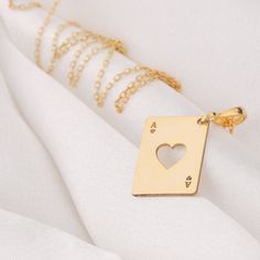 Elegant Silver and Gold Ace of Hearts Pendant Necklace: A Stunning Blend of Precious Metals, Craftsmanship, and Symbolism, Ideal for Both Poker Enthusiasts and Romantics, a Timeless Piece to Elevate Your Style and Spread Love and Luck * Gender : Male / Female * Material Options : 14K Solid Gold, 925 Sterling Silver, Silver Gold Plated * Thickness of Pendant: 0.8 mm * The letters in the corners can be changed upon custom  request * You can write which letter you want in the personalization section and create your order.   * The chain is sent in the same way as the necklace material you choose. * If you prefer a 14k solid gold with triple chains, we will send you the lengths of 37/45/50cm as in one as triple that are presented in the models.  * If you prefer a sterling silver necklace with t Love And Luck, Heart Necklace Silver, Ace Of Hearts, Lucky In Love, Ace Of Spades, Spread Love, Lucky Charm, Personalized Necklace, Heart Pendant Necklace