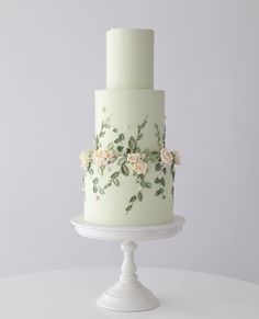 a three tiered cake with flowers painted on it