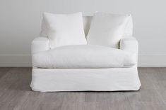 a white couch sitting on top of a hard wood floor