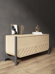 a wooden sideboard with two pictures on top and a gold statue in the background