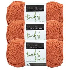 three skeins of yarn with the words touch of love written on each ball