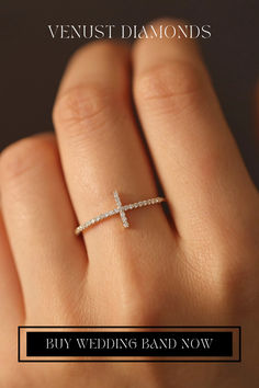 a woman's hand with a diamond cross ring on it and the words, buy wedding band now