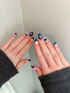 two hands with blue and white nail polish holding each other