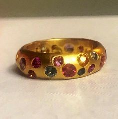 As shown This band measure 5.5 wide. It can be made in any width and the pricing is reflected in the info below. Ask for a custom listing for your specific width. The beautiful multi-colored sapphires and rubies are cast in place into buttery yellow 22k gold. Choose your colors or go wild using all different colored sapphires as shown. Can also be made in 18k for $175 less Price adjusted for under size 5 or over 8.5. 5.5mm wide $2500 6mm wide $2600 6.5mm wide $2700 7mm wide $2800 7.5mm wide $290 Colored Sapphires, Sapphire Band, Dope Jewelry, Go Wild, Stacking Ring, 22k Gold, Stacking Rings, Multi Colored, Cuff Bracelets