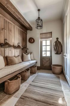 a wooden bench sitting in the middle of a hallway next to a door and baskets