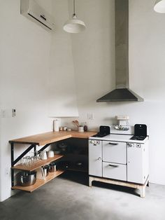 a kitchen with an oven, stove and shelves on the wall next to each other