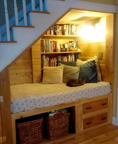 a book shelf under the stairs is filled with books