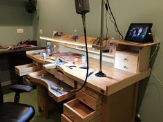 a wooden desk with drawers and electronics on it