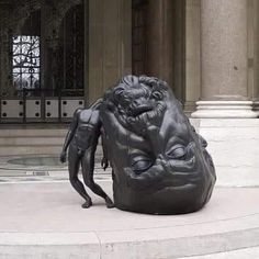 a statue of a man sitting in front of a building