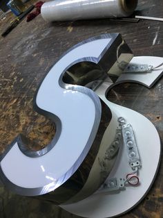 the letter s is made out of metal and has letters cut out to spell it