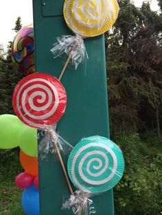 some paper plates are hanging on a pole