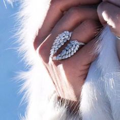 a close up of a person's hand with two rings on their fingers, in the snow