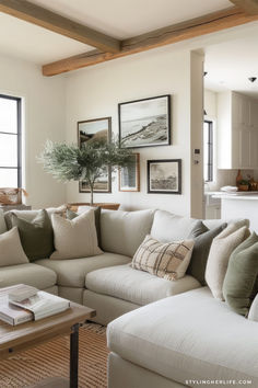 a living room filled with lots of furniture and pictures on the wall above it's windows