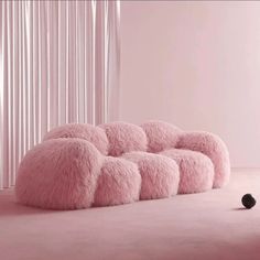 a pink room with several fluffy balls on the floor